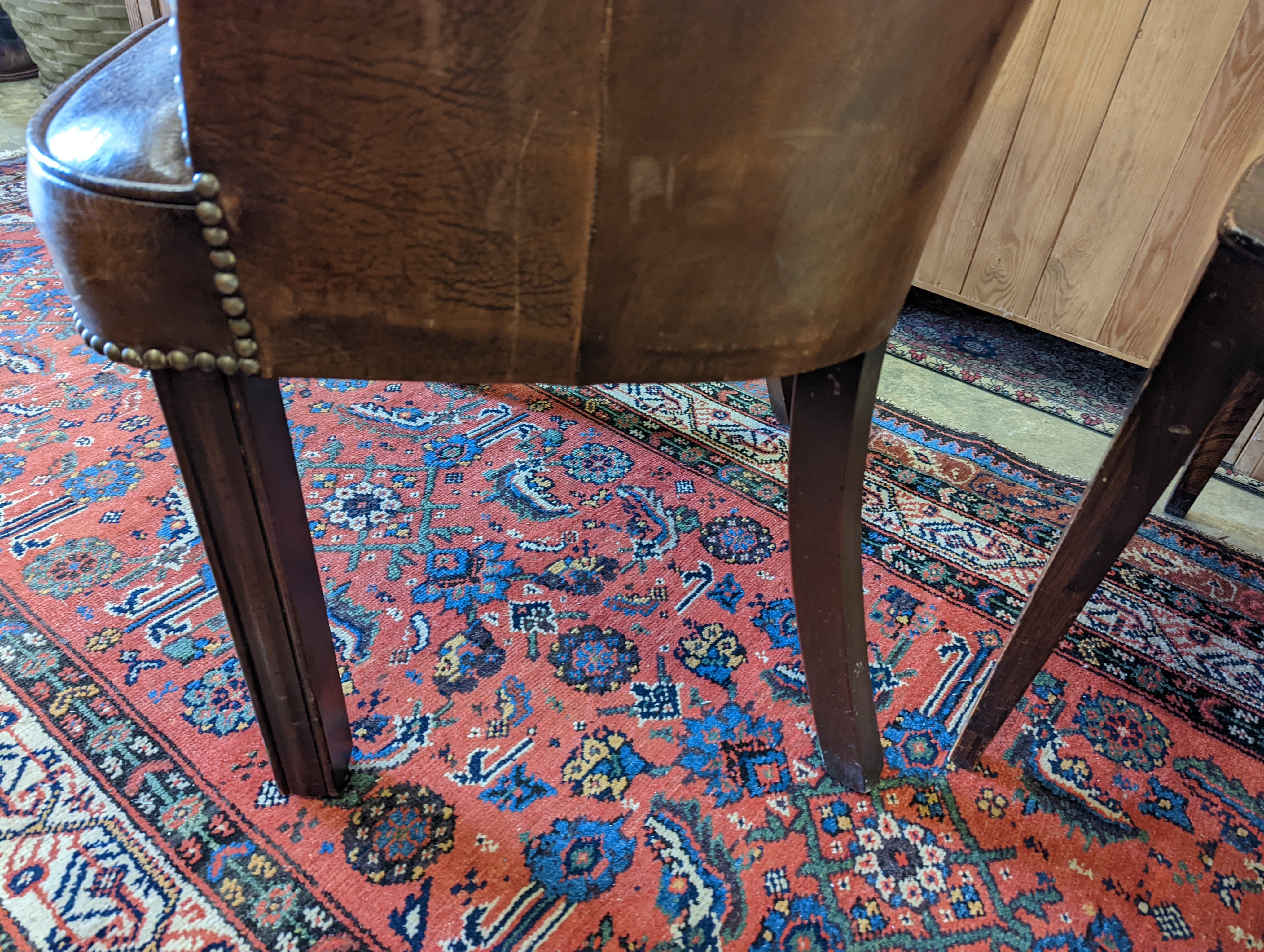 A brown leather upholstered desk chair, a mahogany hall chair and two upholstered armchairs